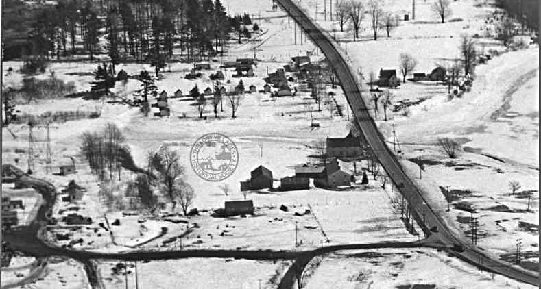 MAPLE GROVE AT ROBERTSON CREEK Looking east, the French-Robertson house, first house on the left, northside of hwy #2. Beyond is the frozen Robertson Creek and summer cabins.  At the very top right hand corner one can just make out the tombstones in the Maple Grove cemetery.  The roads at the bottom of the photo lead to a construction camp. 